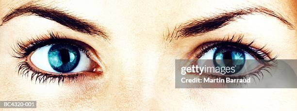 young woman's eyes, close-up (cross-processed) - twins stock pictures, royalty-free photos & images