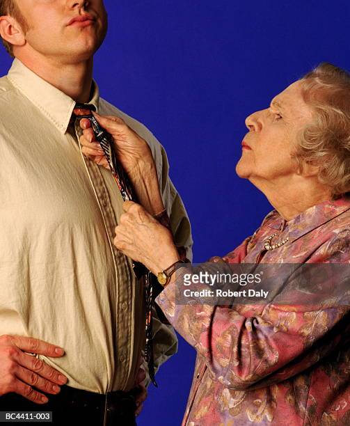 elderly woman tying young man's tie, close-up - sogra imagens e fotografias de stock