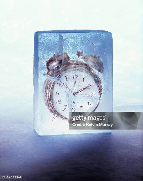 alarm clock frozen in block of ice (digital composite) - 氷　塊 ストックフォトと画像