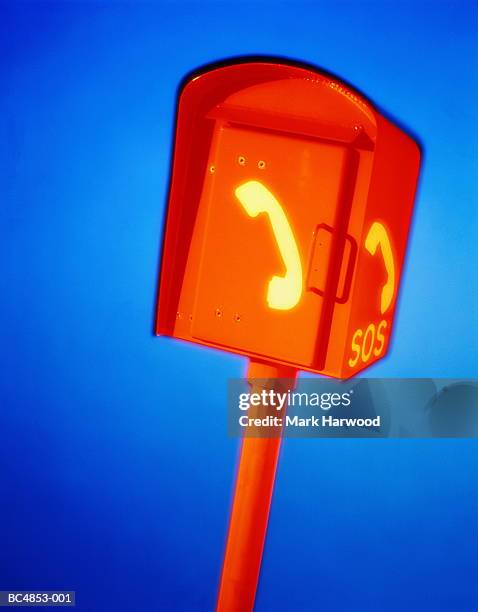 emergency telephone box against blue background (brightly lit) - emergency telephone box stock pictures, royalty-free photos & images