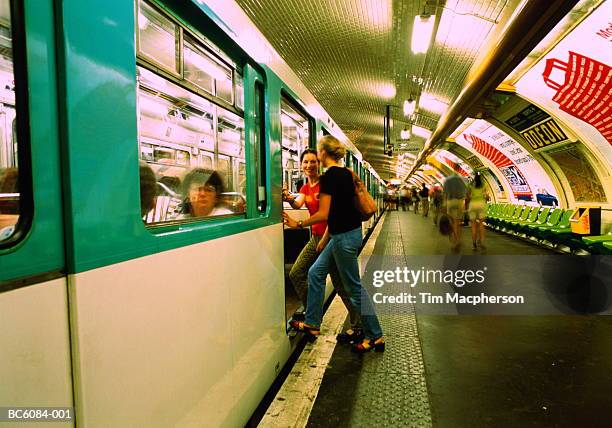 two teenage girls (17-19) getting on train in metro, paris, france - paris metro stock pictures, royalty-free photos & images