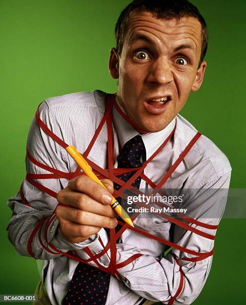 businessman bound up in red tape, close-up - administrative professional stock pictures, royalty-free photos & images