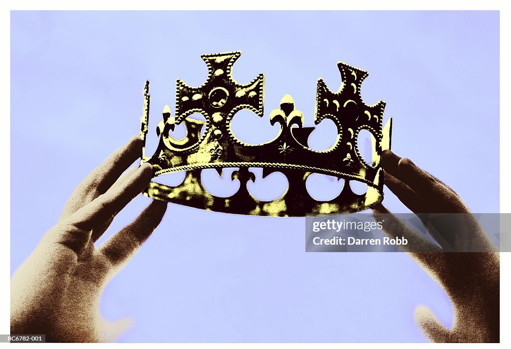 Hands holding up crown, close-up (toned B&W)
