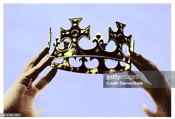 hands holding up crown, close-up (toned b&w) - corona accesorio de cabeza fotografías e imágenes de stock