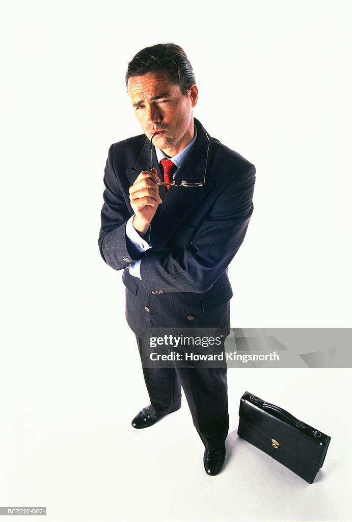 Businessman standing with pensive expression, elevated view