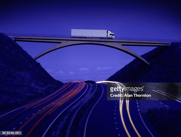 lorry crossing bridge above motorway, dusk (digital composite) - bridge side view stock pictures, royalty-free photos & images