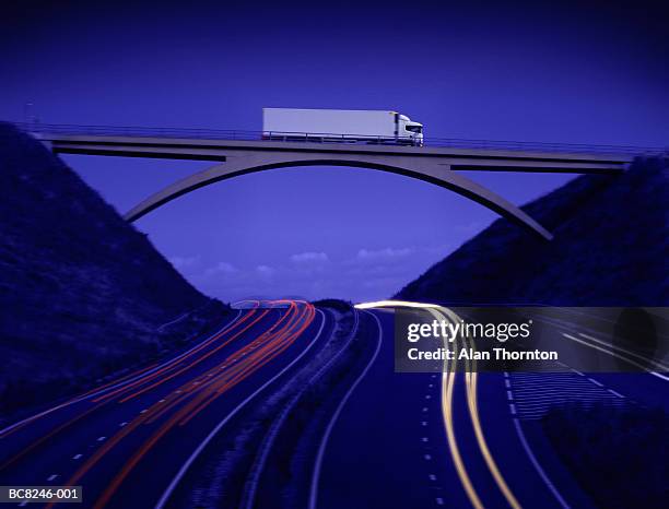 lorry crossing bridge above motorway, dusk (digital composite) - semi truck headlight stock pictures, royalty-free photos & images