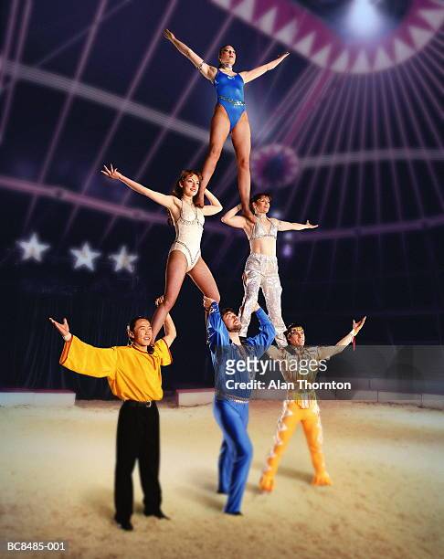 circus performers forming human pyramid in big top (composite) - circo imagens e fotografias de stock
