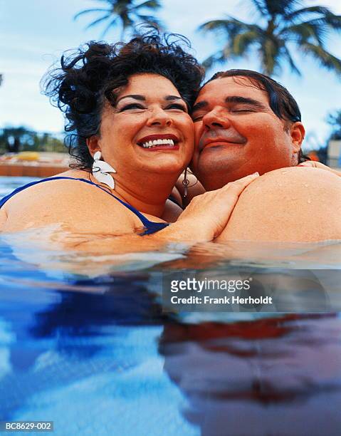 overweight couple in swimming pool, embracing, close-up - fat couple photos et images de collection