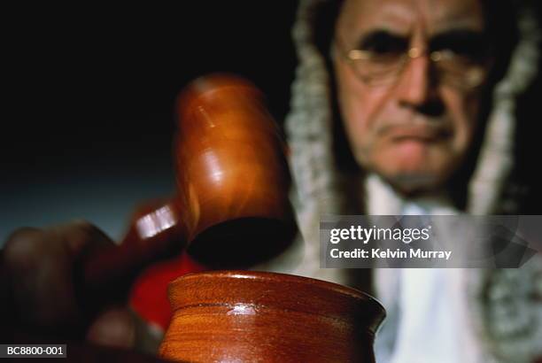 judge using gavel in court (focus on foreground, blurred motion) - judge stockfoto's en -beelden