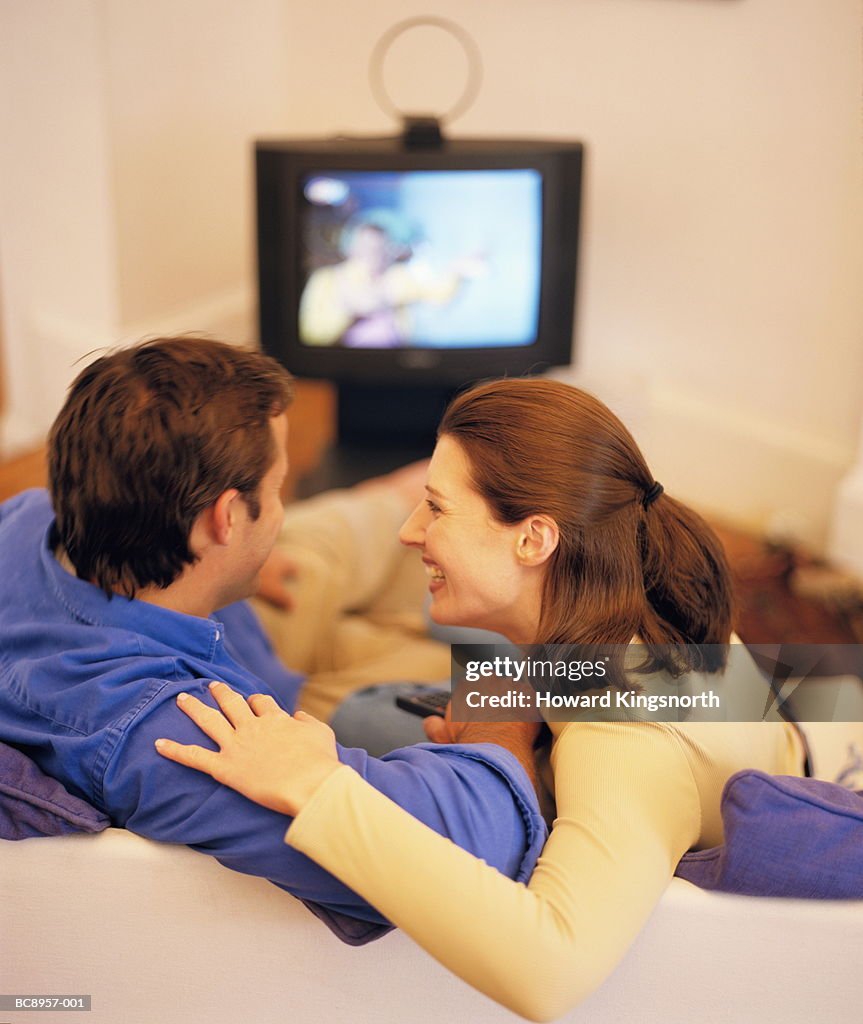 Couple watching television, rear view