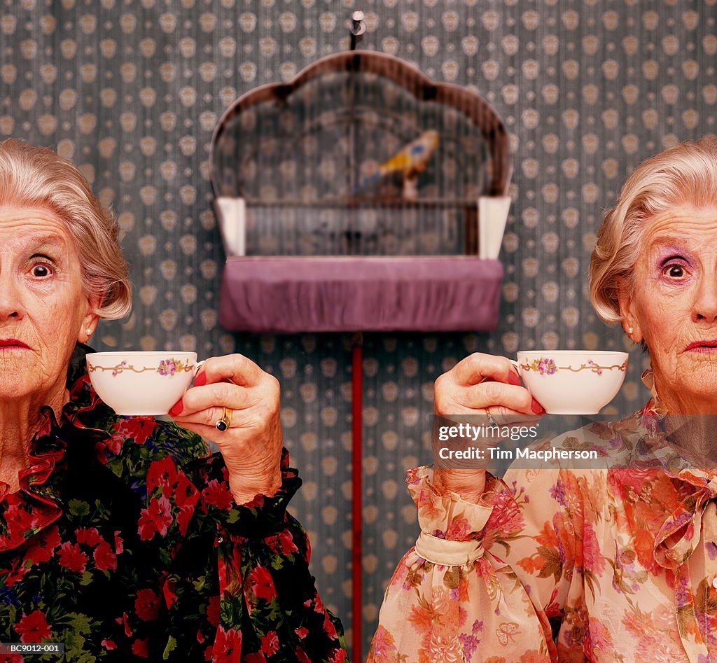 Two elderly women drinking tea, birdcage in background (Composite)