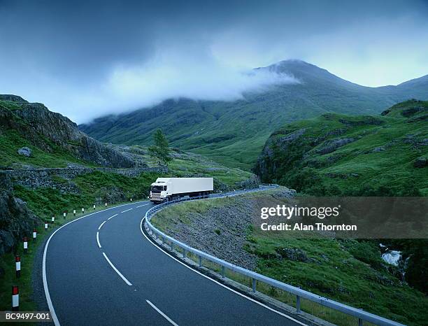 white lorry on road through rural landscape (digital composite) - 大型トレーラー ストックフォトと画像