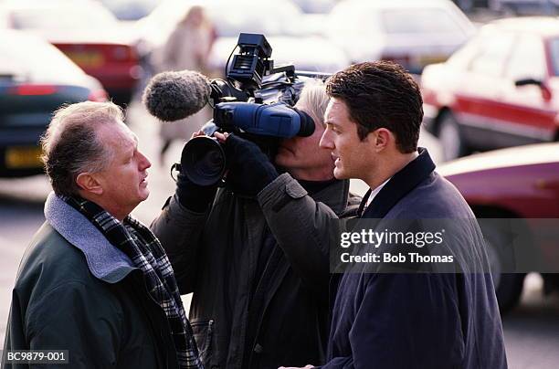 television crew interviewing person in car park - journalists stock pictures, royalty-free photos & images