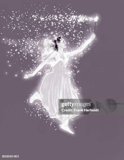 young woman in fairy costume, wand emitting sparkles (enhancement) - feenkostüm stock-fotos und bilder