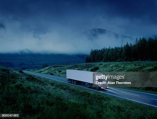 white lorry driving along country road at night (digital enhancement) - haulage stock pictures, royalty-free photos & images