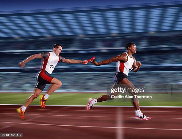 relay race, male athletes passing relay baton (digital composite) - relay fotografías e imágenes de stock