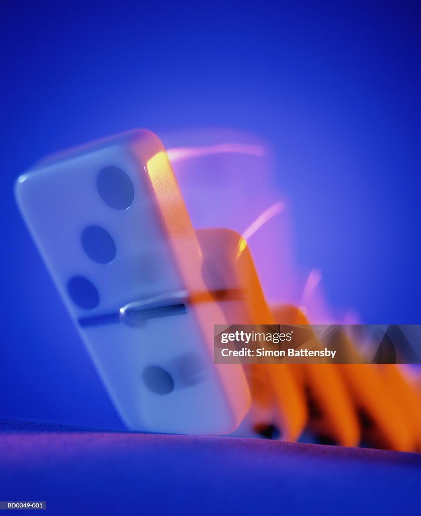 Row of dominoes falling down, close-up (blurred motion)