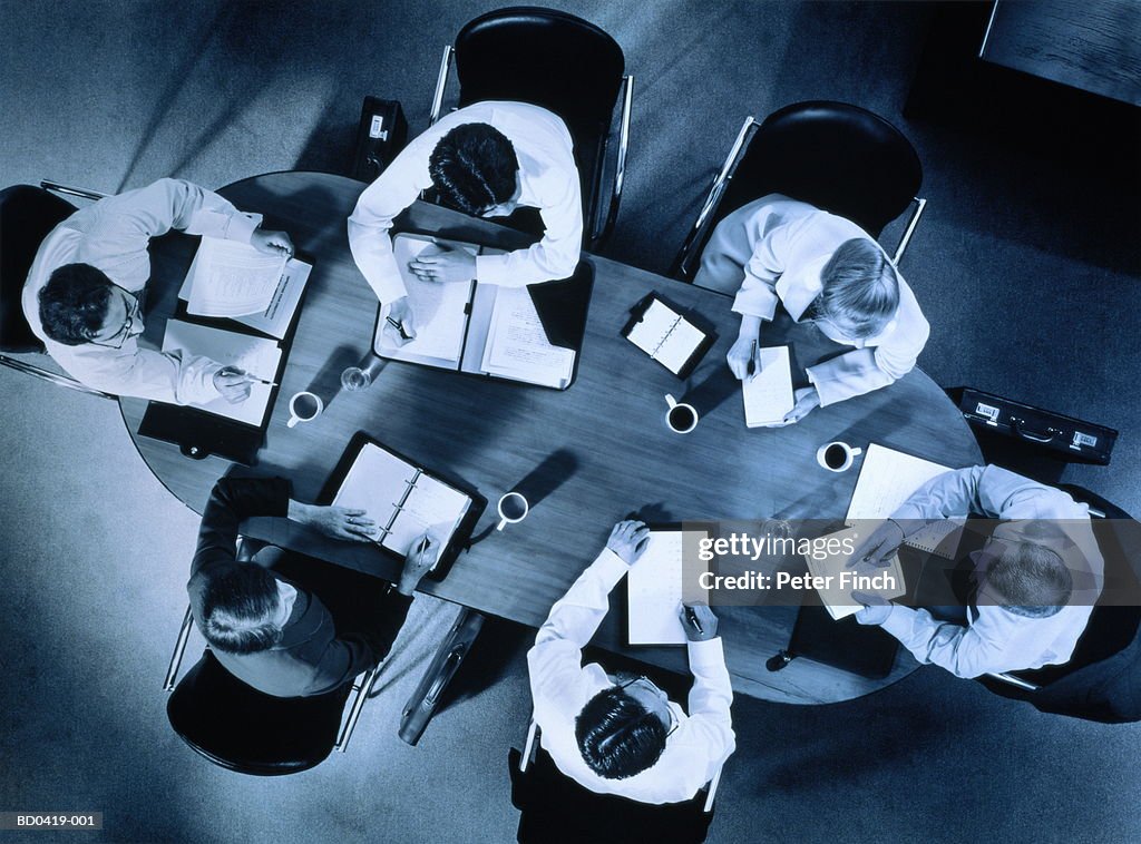 Group of executives sitting around table, overhead view (toned B&W)