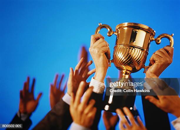 hands reaching for trophy (digital composite) - awards trophies stock pictures, royalty-free photos & images