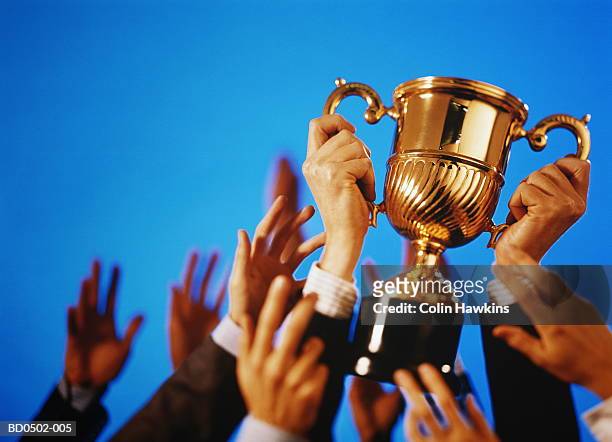 hands reaching for trophy (digital composite) - awards inside imagens e fotografias de stock