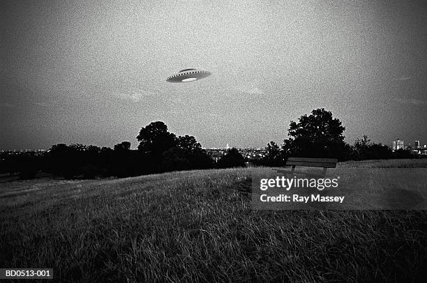 ufo in flight above urban park (digital composite) - alien stock pictures, royalty-free photos & images