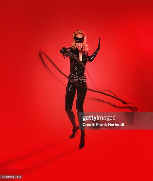 young woman wearing bodysuit, cracking whip (digital enhancement) - whipping woman stock pictures, royalty-free photos & images