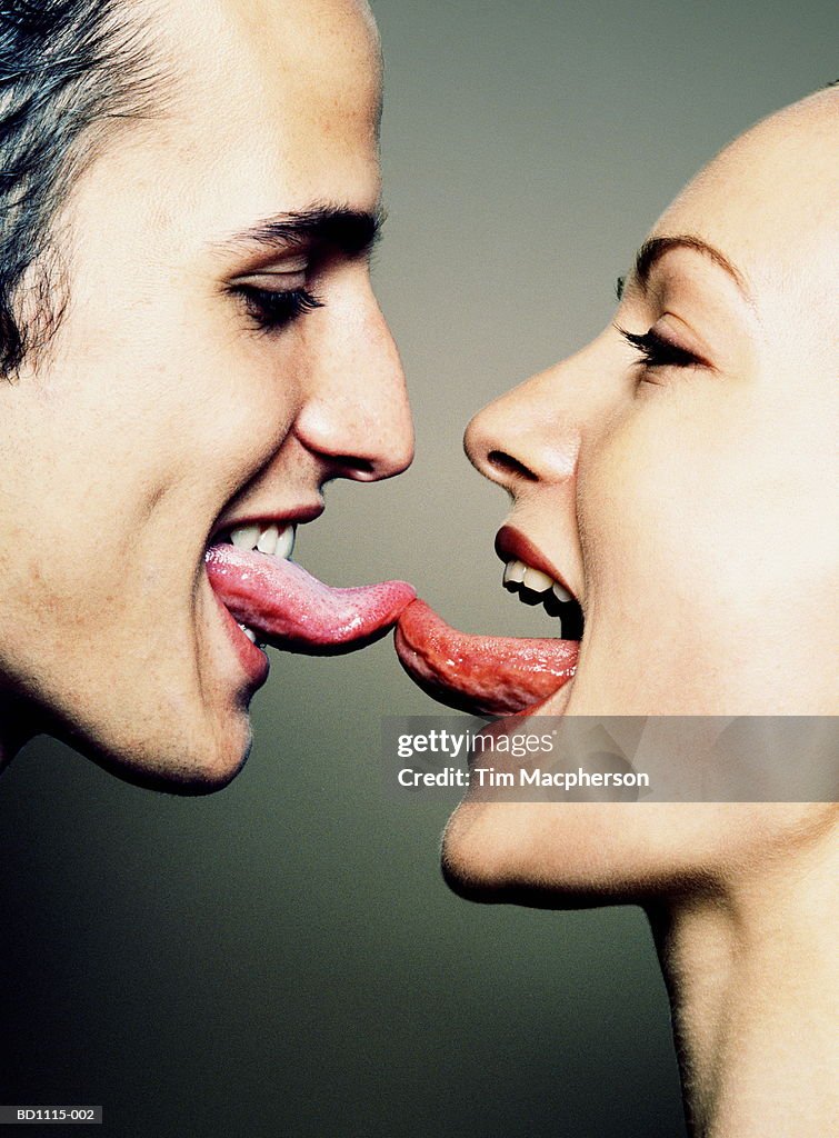 Young couple with tongues touching, close-up, profile