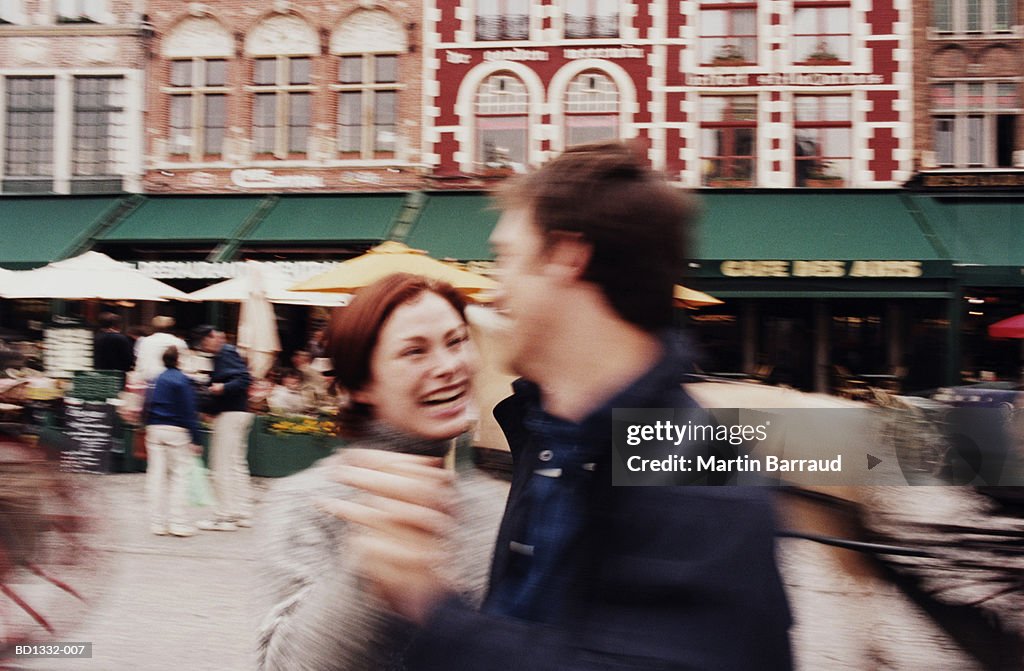 Couple dancing outside cafe, Bruges, Belgium (blurred motion)