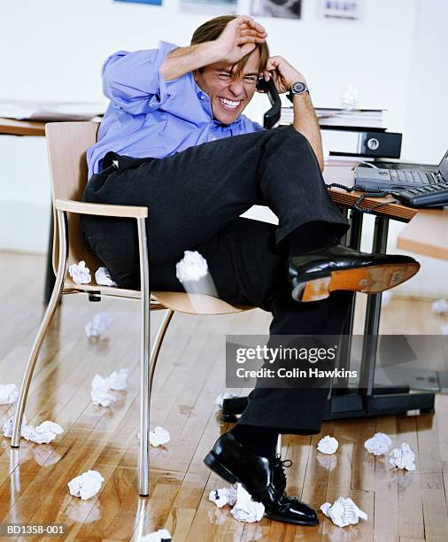 young male executive using telephone, dodging paper balls - dodging stock pictures, royalty-free photos & images