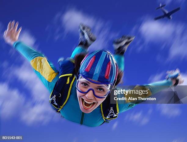 young woman skydiving, close-up, low angle view (digital composite) - indoor skydive stock pictures, royalty-free photos & images