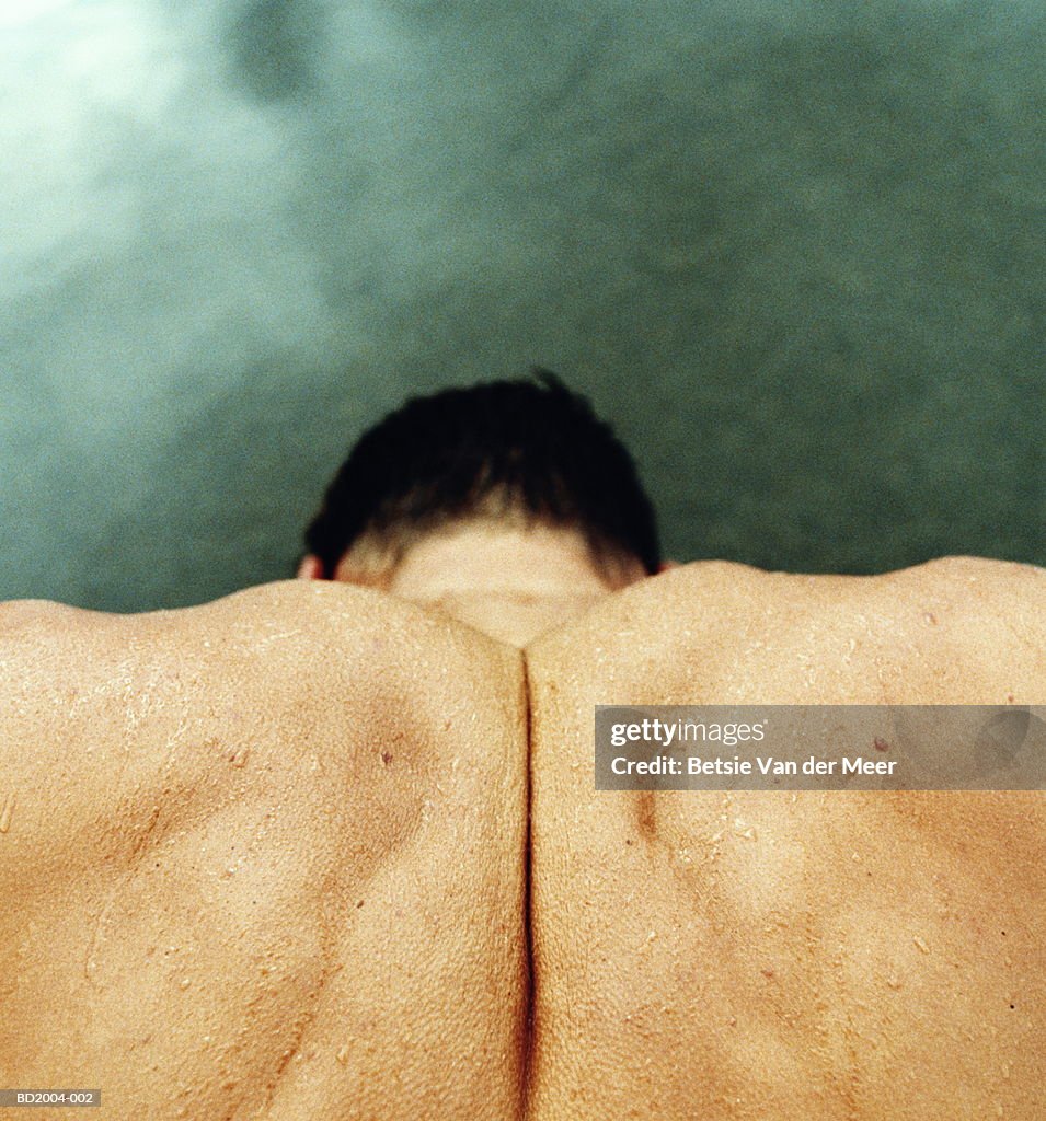 Man's clenched shoulders, close-up, elevated view