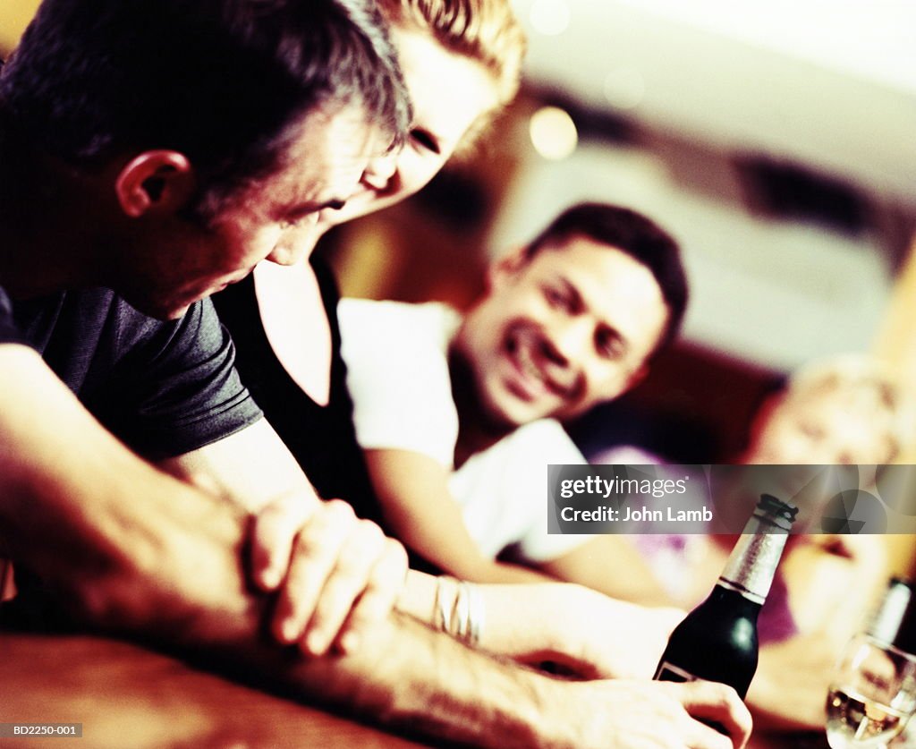 Group of young people in wine bar talking and drinking (Enhancement)