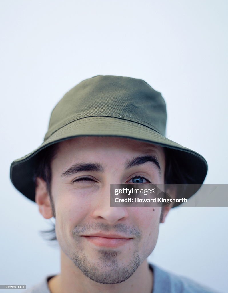 Young man wearing green hat, winking, portrait