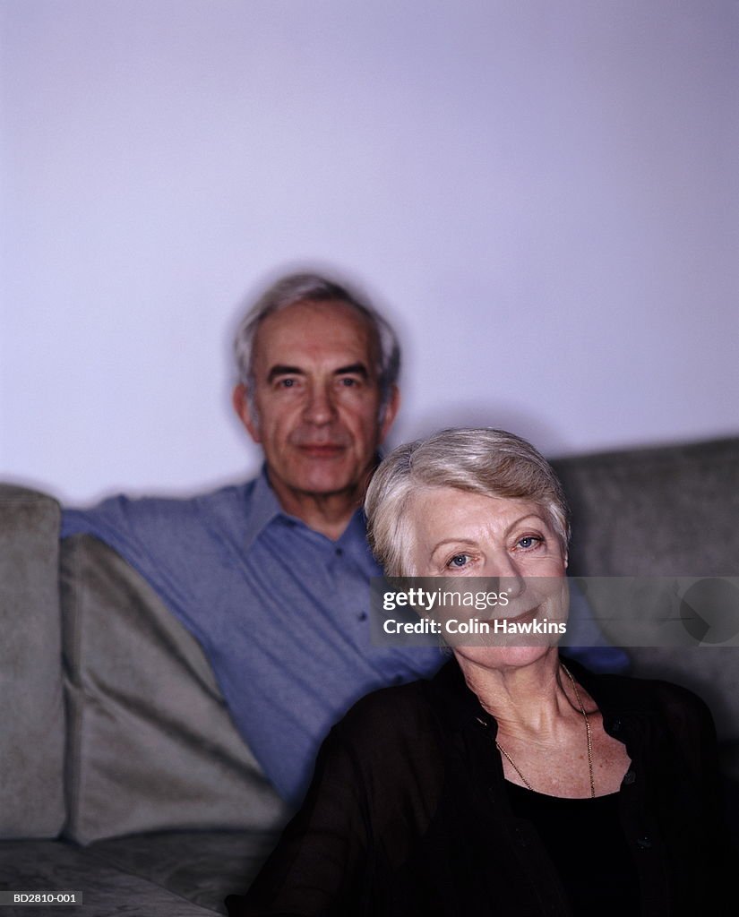 Mature couple sitting on sofa, portrait (Digital Enhancement)