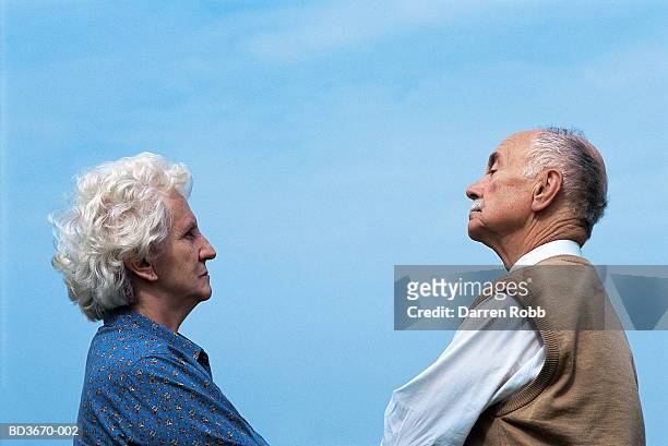 elderly couple face to face, looking pensive - diverbio foto e immagini stock