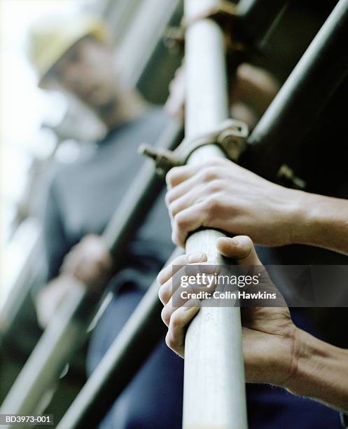 two men on scaffolding, low angle view - baugerüst stock-fotos und bilder