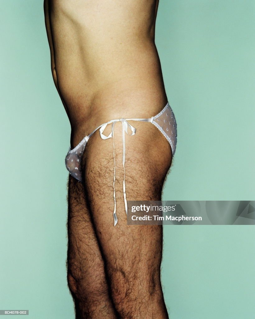 Hairy man wearing woman's knickers, side view, close-up
