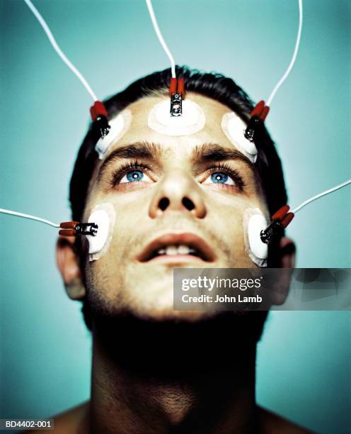 young man with electrodes on face, close-up - electrode stock pictures, royalty-free photos & images