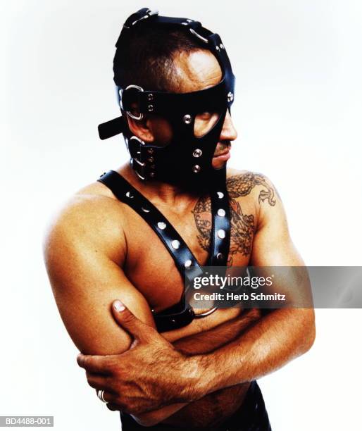 man wearing fetish mask and leather straps, dragon tattoo on shoulder - s & m stock-fotos und bilder