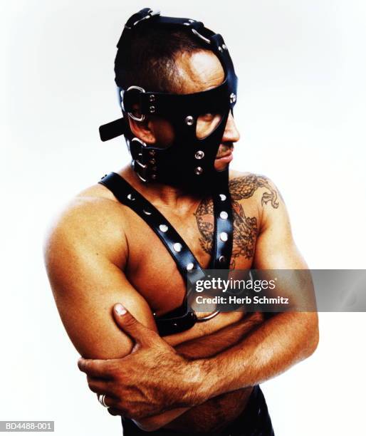 man wearing fetish mask and leather straps, dragon tattoo on shoulder - imbracatura di pelle foto e immagini stock