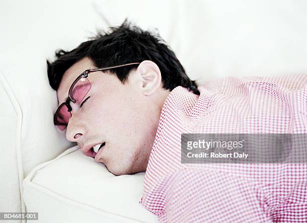 young man sleeping on couch, close-up - schnarchen mann stock-fotos und bilder
