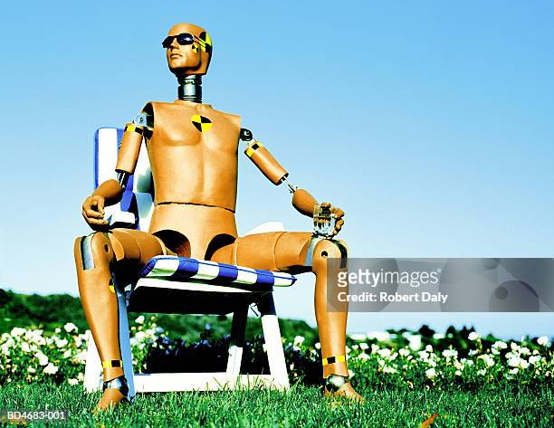 crash test dummy sitting on garden chair, holding drink - crash test dummies stock-fotos und bilder