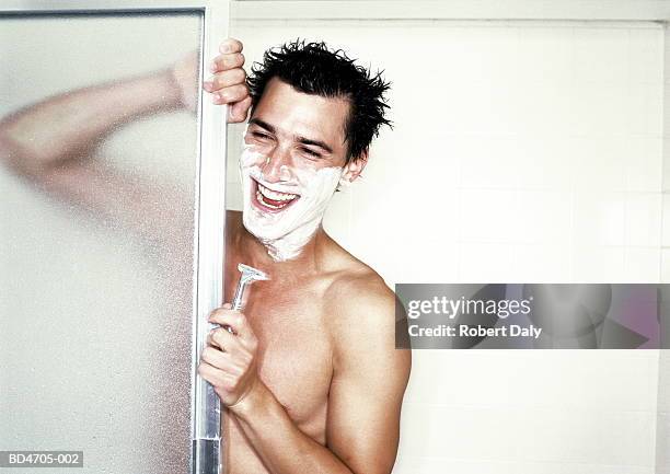 young man shaving in shower, laughing, close-up - hombre en la ducha fotografías e imágenes de stock