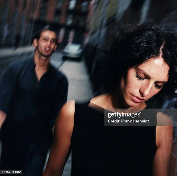 young man following woman along street (blurred motion) - freundin beziehung stock-fotos und bilder