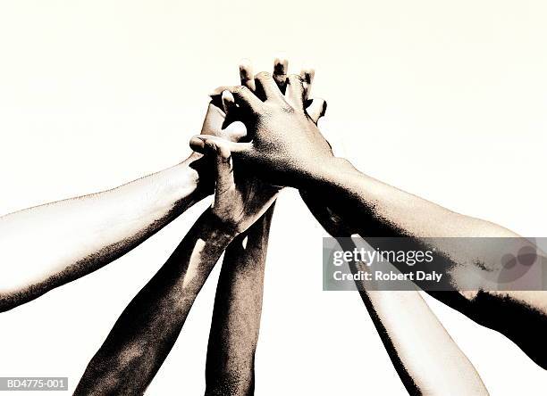 group of young people's hands clasped together (toned b&w) - unión fotografías e imágenes de stock