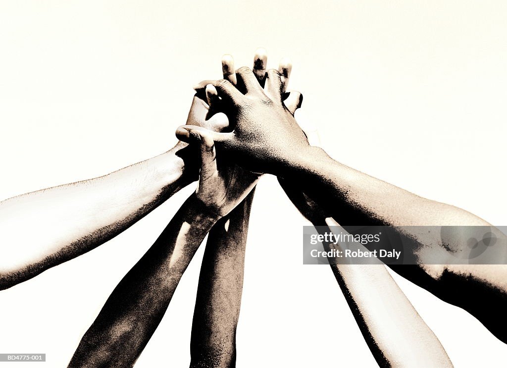 Group of young people's hands clasped together (toned B&W)