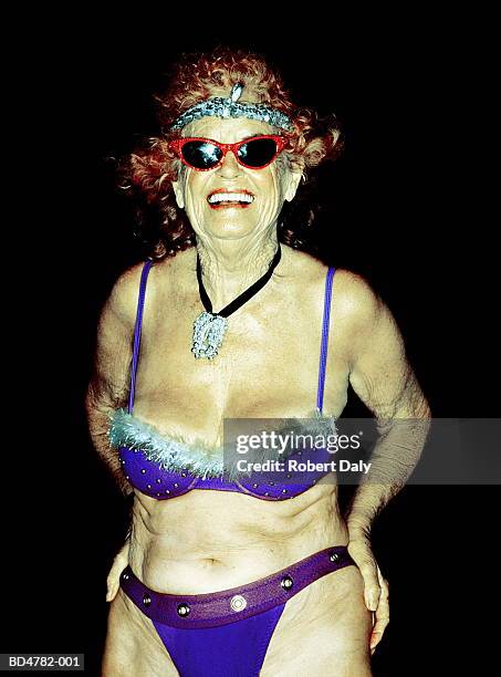 elderly woman wearing blue bikini and sunglasses, portrait - old woman in swimsuit stock-fotos und bilder
