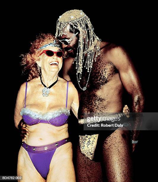 mature man in sequinned codpiece, with elderly woman in bikini - black women in swimsuits stock pictures, royalty-free photos & images