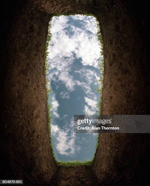 cloudy sky seen from bottom of grave (digital enhancement) - friedhof stock-fotos und bilder